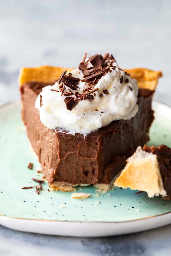 Chocolate pie on a plate with a bite taken out of it. 