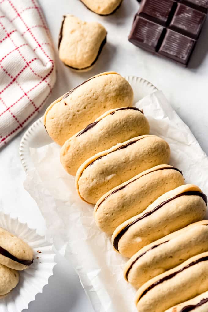 Milano cookies stacked together on a white dish. 