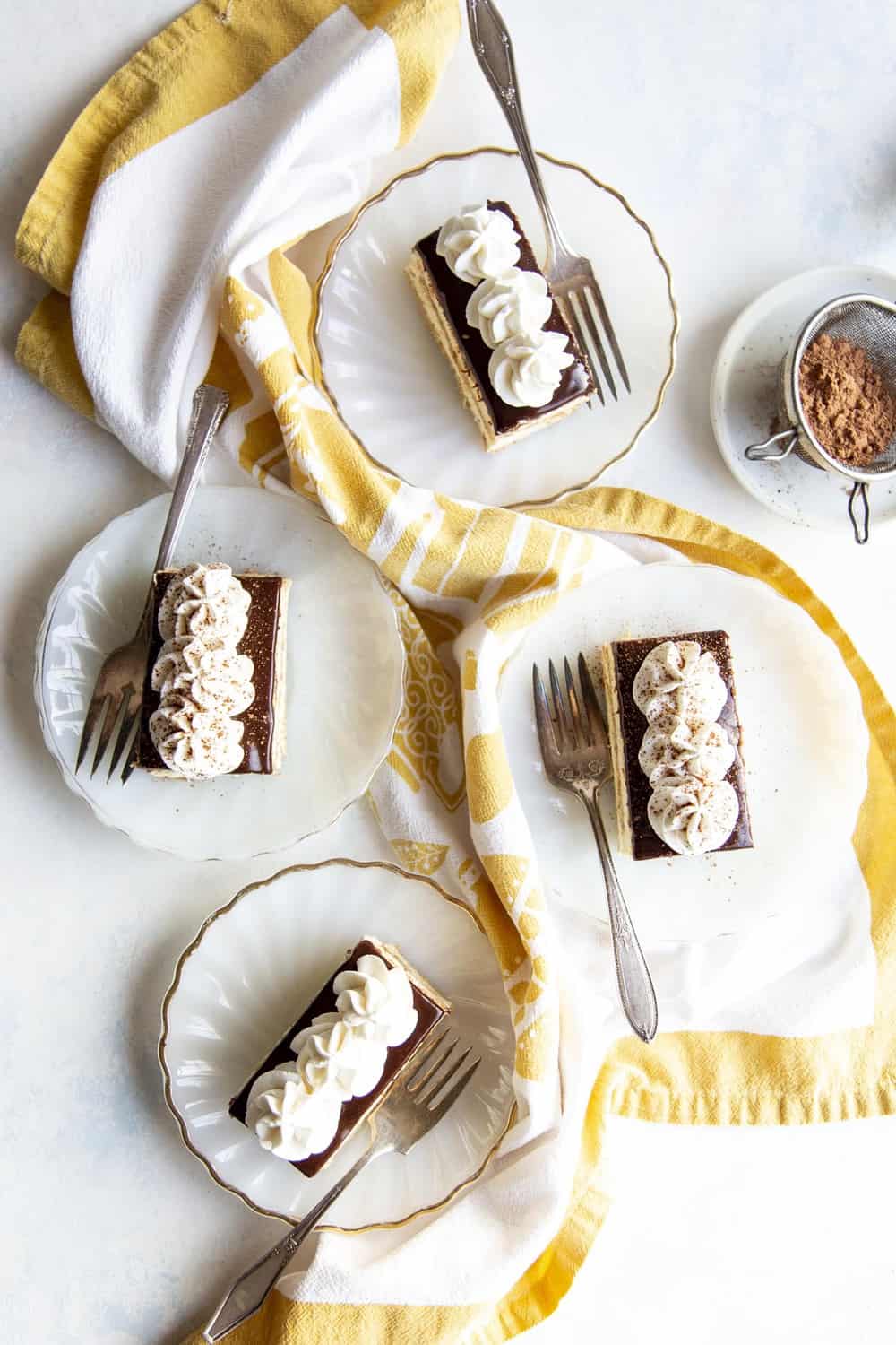 Four slices of cake on white plates. 