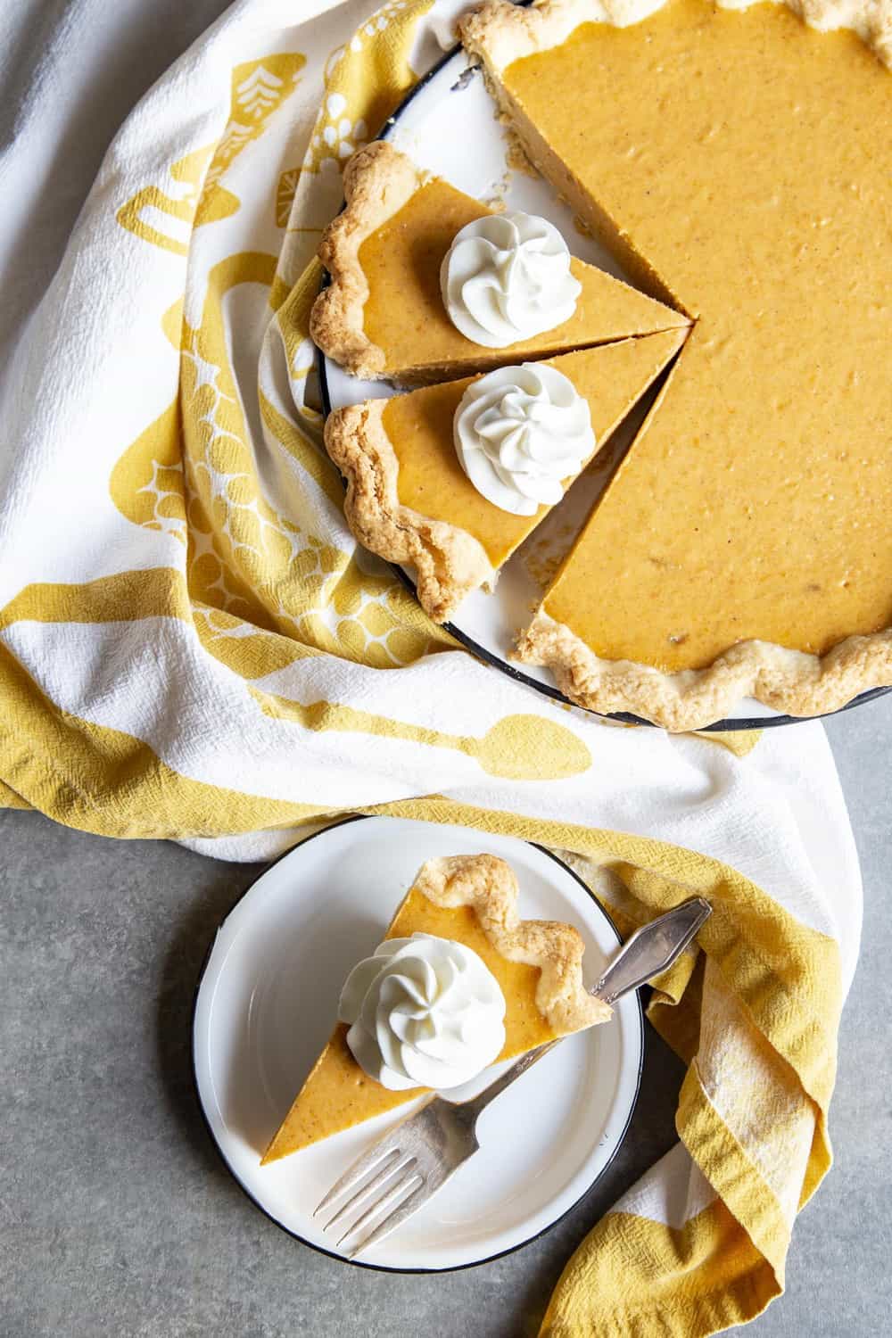 A slice of sweet potato pie on a plate next to the pie in the pie dish