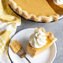 Partial eaten slice of sweet potato pie on a plate next to the pie dish