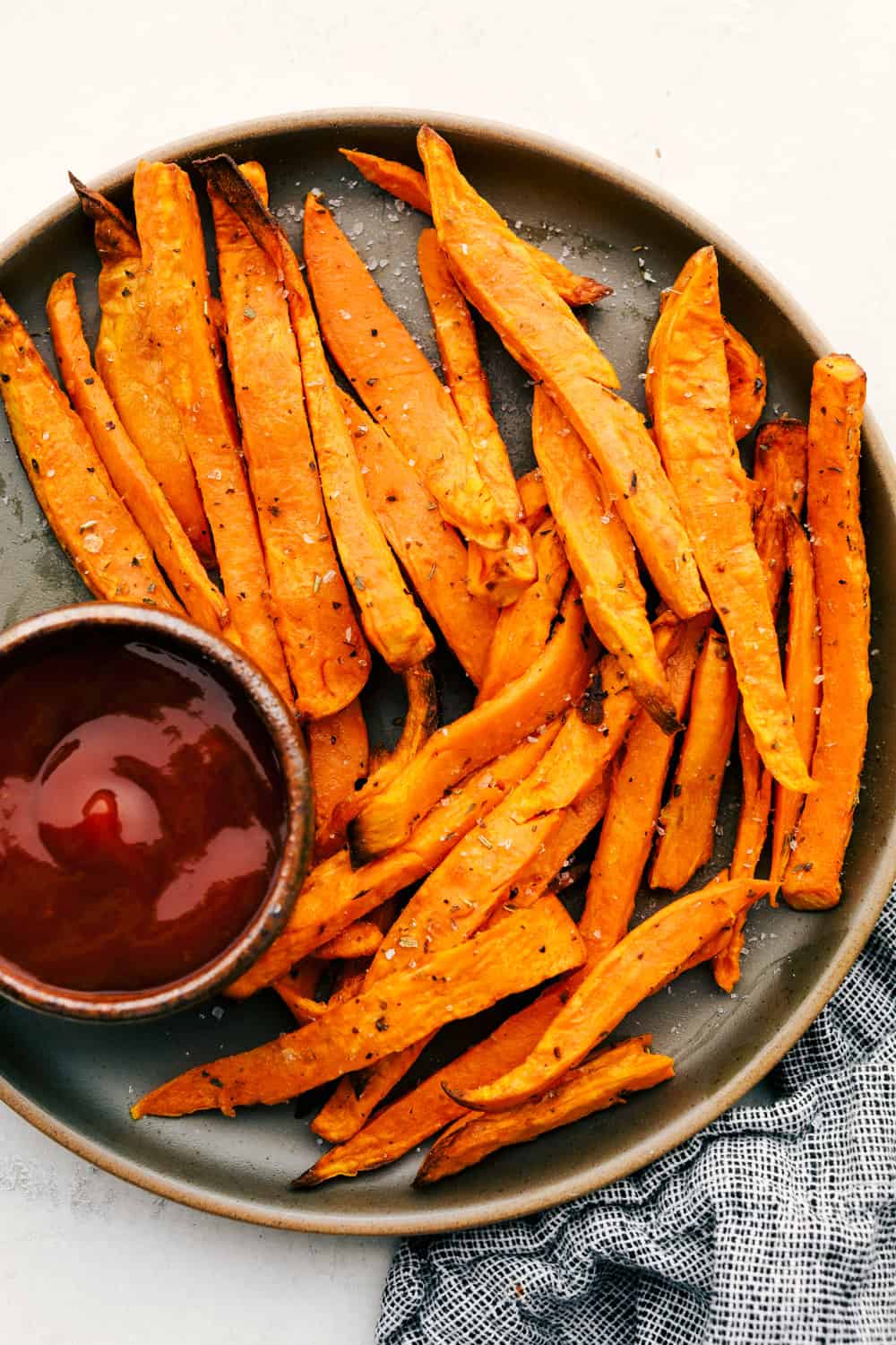 Sweet potato fries on a plate with sauce for dipping.