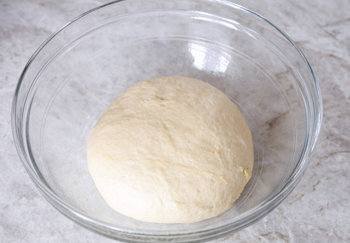 Overhead shot of lion house rolls dough in a greased bowl. 