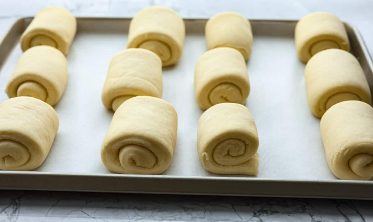 Angle shot of rolled dough on a baking sheet. 