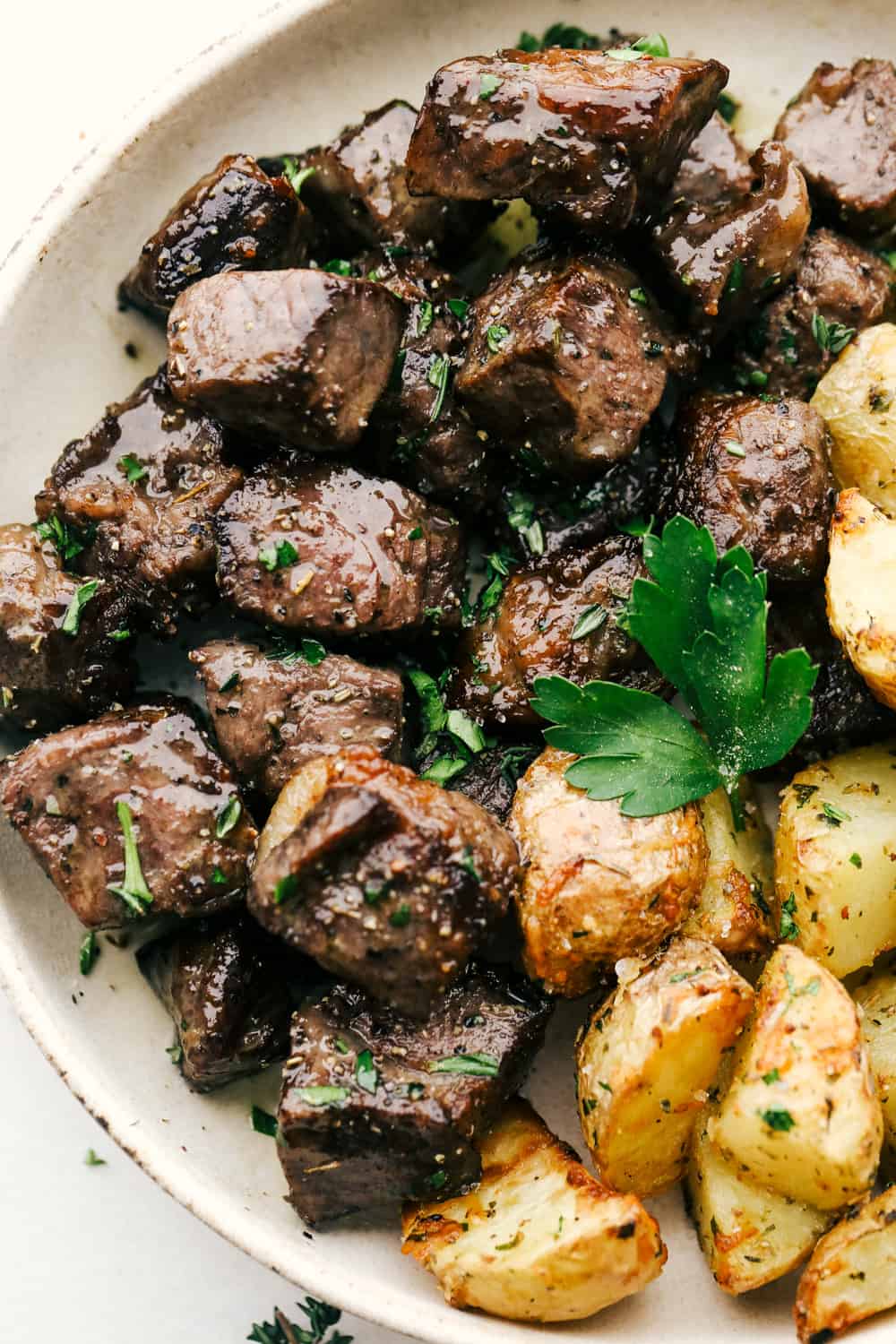 Air Fryer steak bites with roasted potatoes on a plate. 