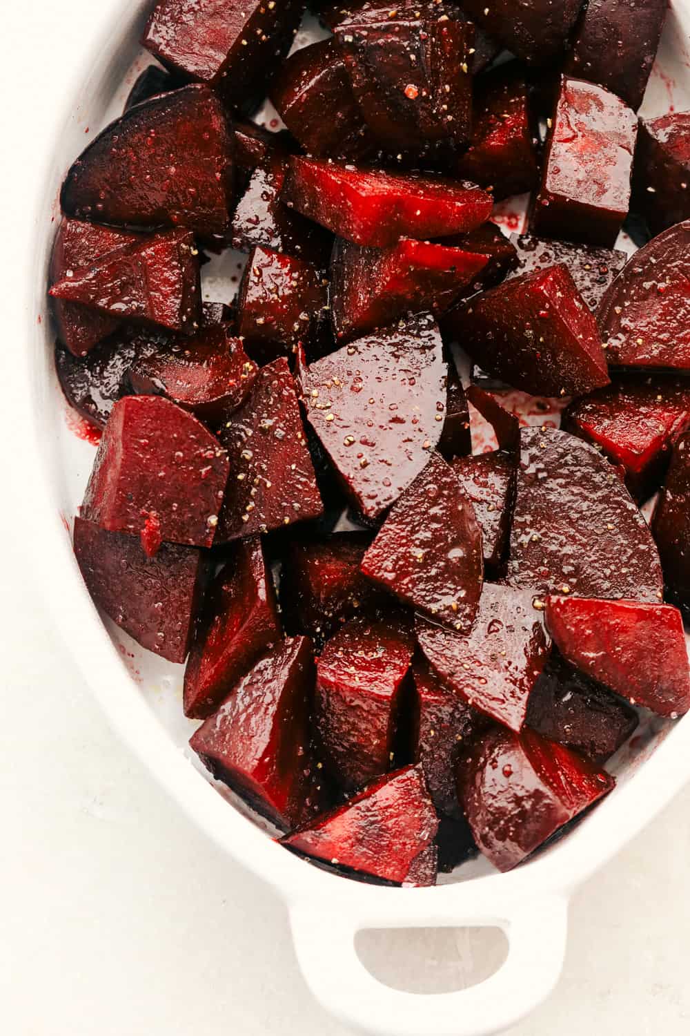 Seasoned beets in a roasting pan. 