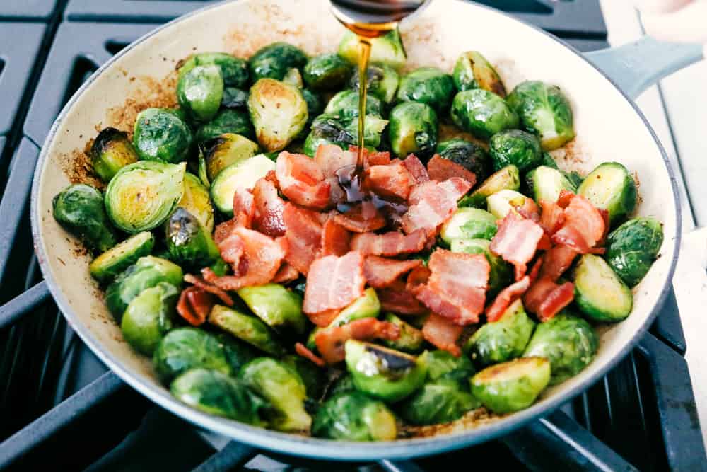 Pouring the maple syrup over the brussel sprouts and bacon.