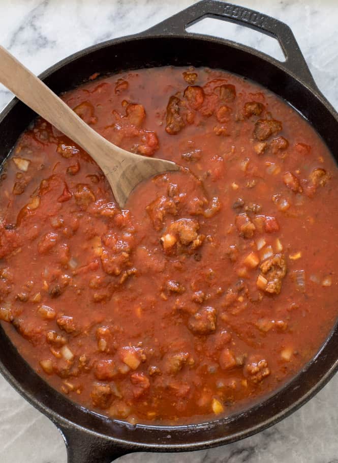 Lasagna in a pot with a wooden spoon. 