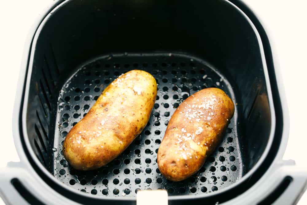 Potatoes in the air fryer sprinkled with kosher salt. 