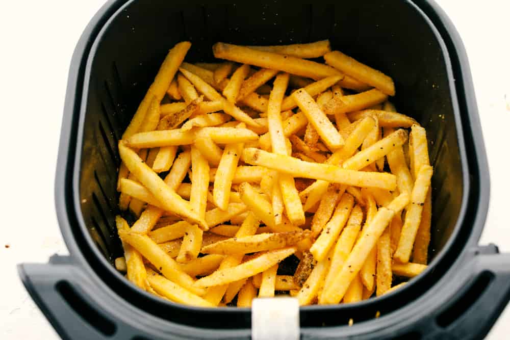 Up close picture of french fries in air fryer basket.