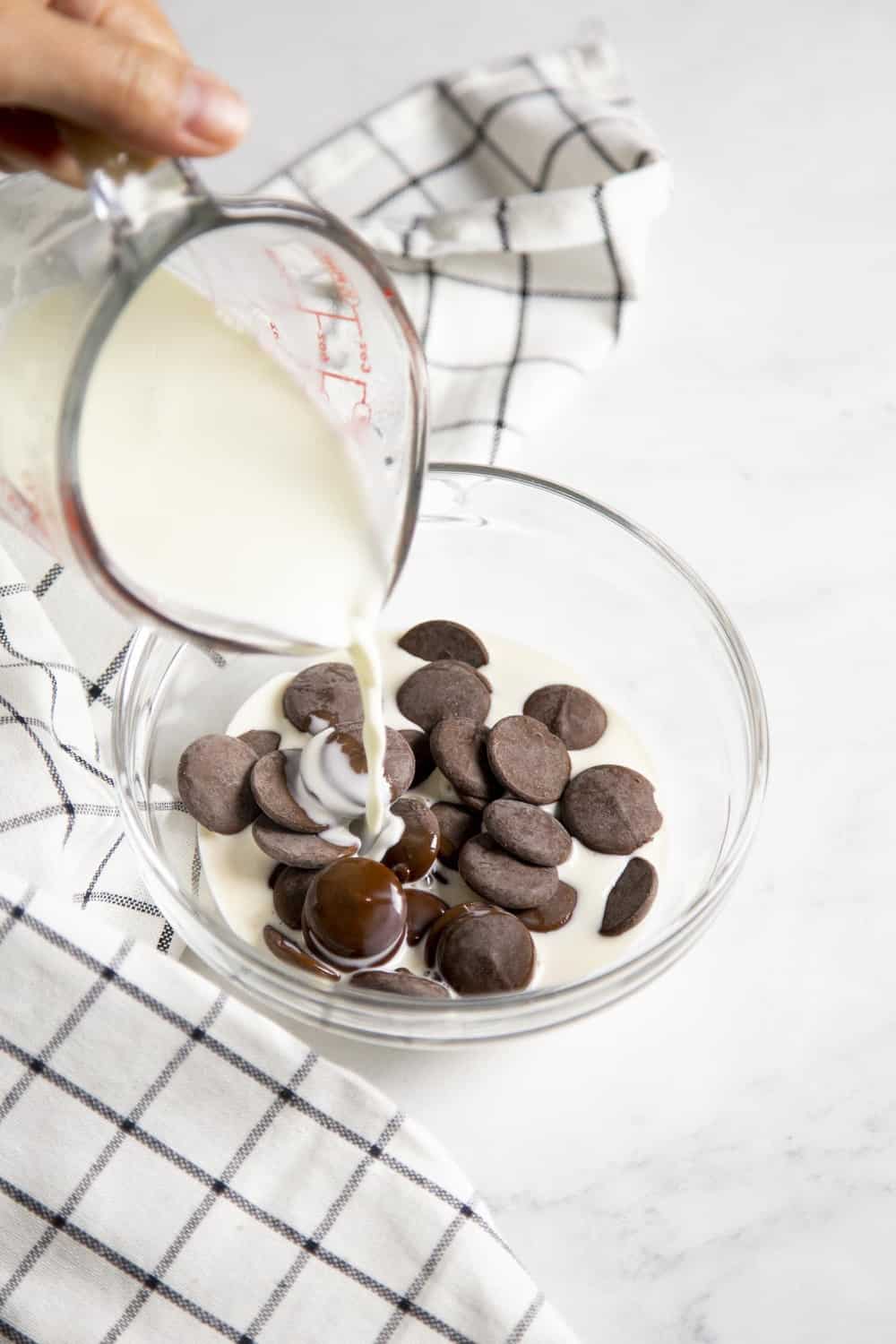 Combining hot cream with chocolate to make ganache. 