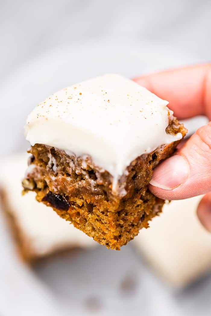 A hand holding a carrot cake bar.