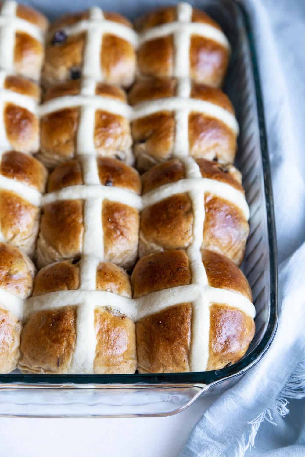 Golden brown Hot Cross Buns in a pan. 