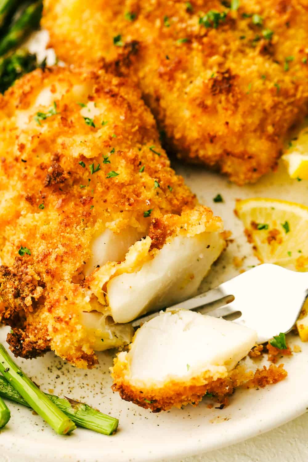 Upclose picture of a fork cutting into the air fryer cod. 