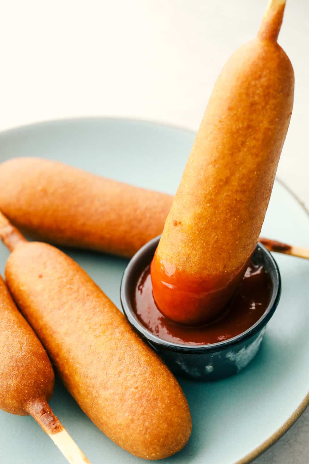 Dipping a corn dog in ketchup. 