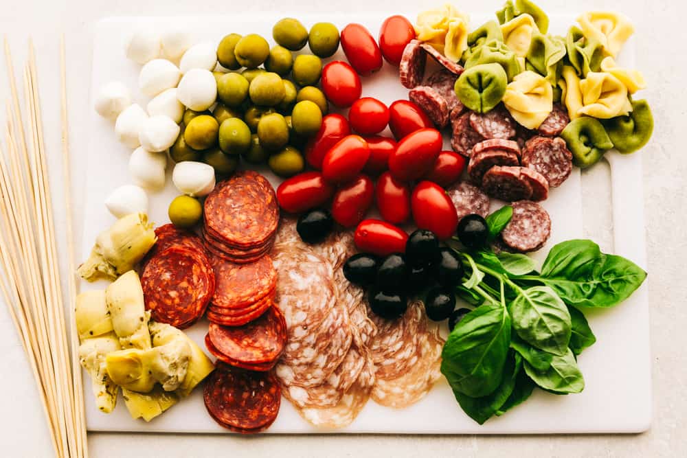 Ingredients for antipasto skewers on a cutting board ready to be assembled.