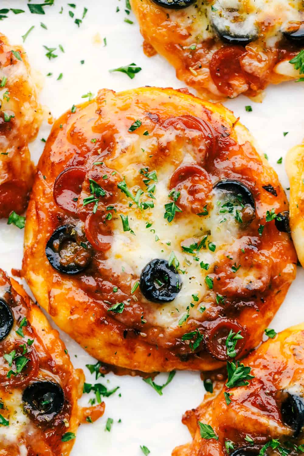 Biscuit air fryer pizza on a plate with cheese pepperoni and olives. 