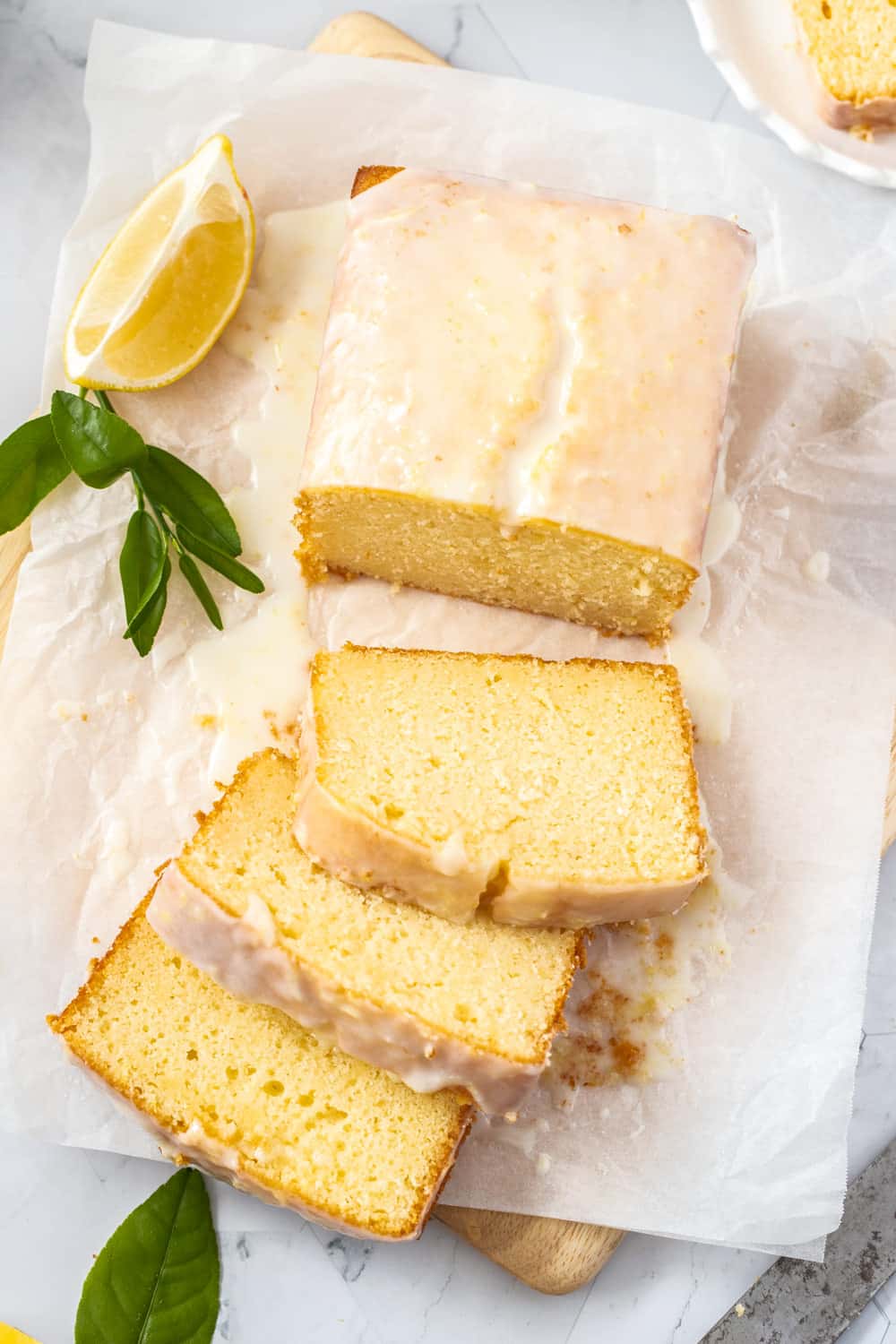 Birdseye view of a glazed cake on a sheet of baking paper.