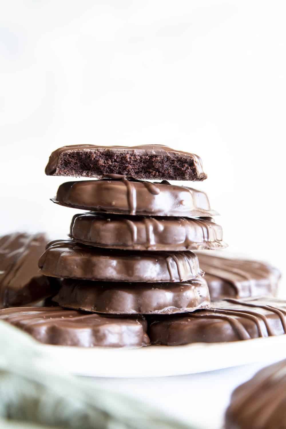 A half eaten thin mint cookie on stack of cookies. 