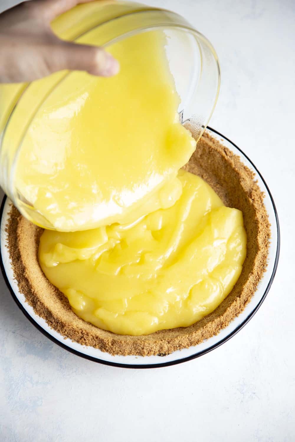 Pouring the lemon filling in the pie crust. 