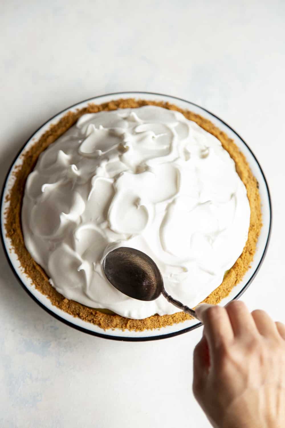 Making designs with a spoon in the meringue. 