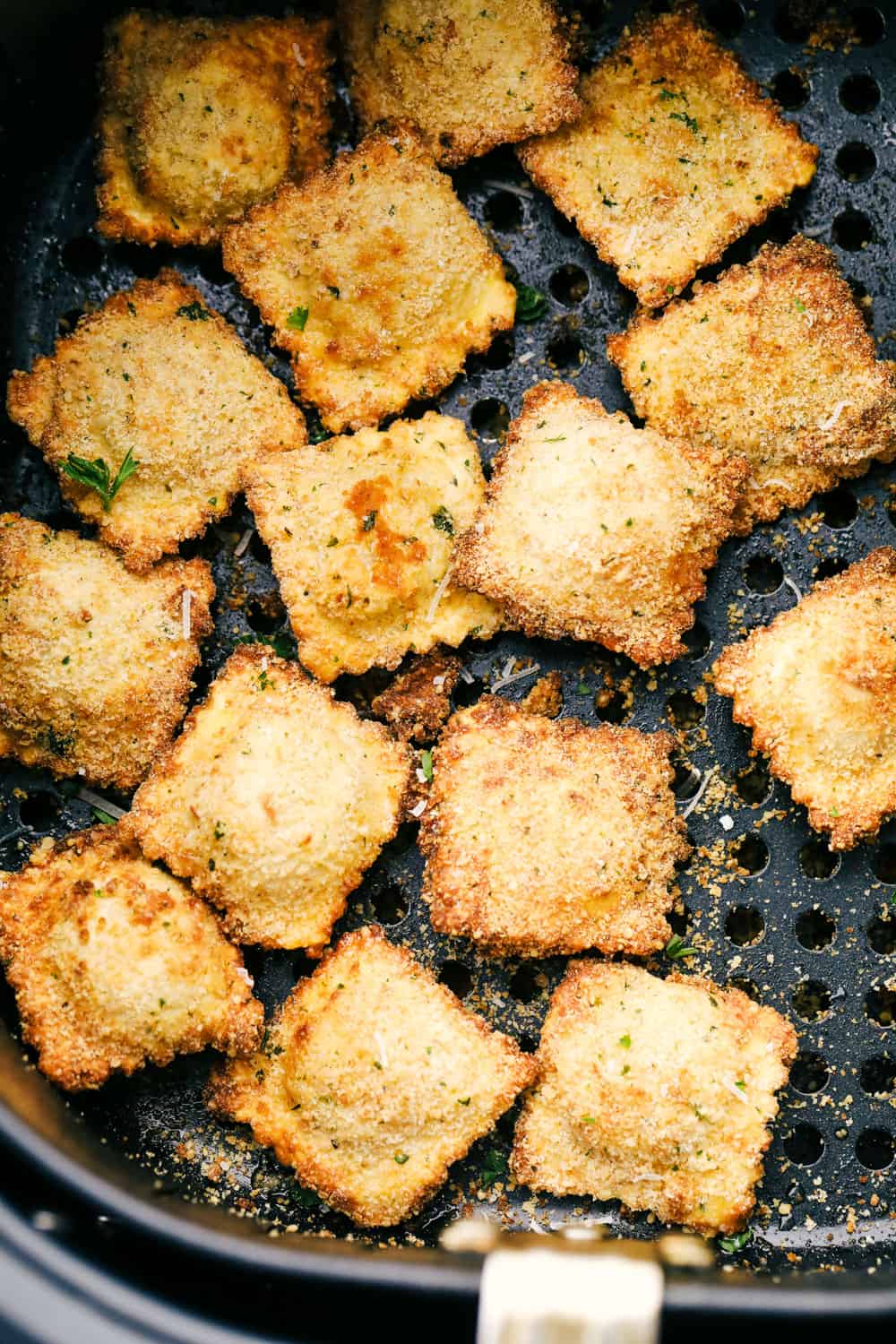 Air fryer ravioli in the air fryer basket. 