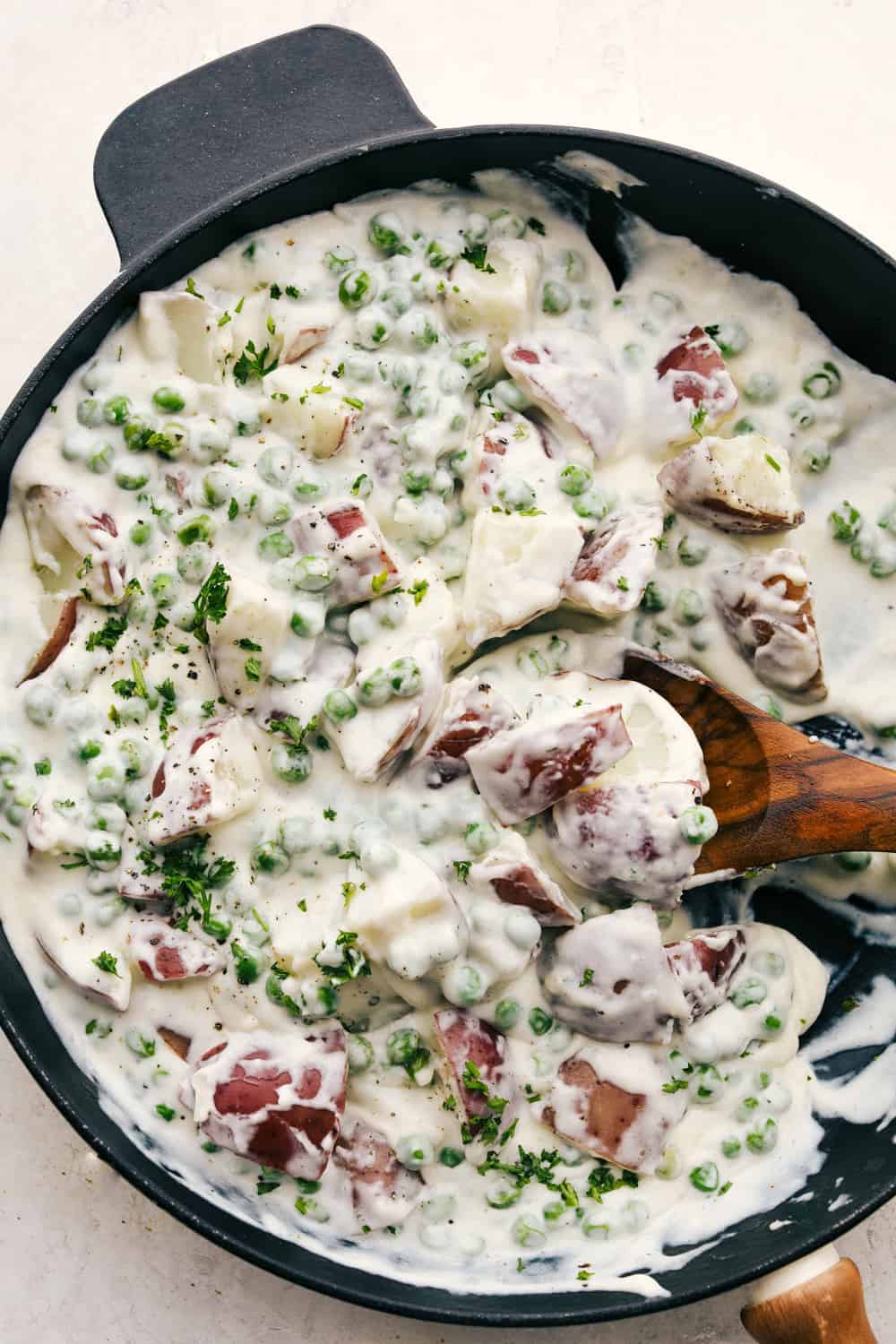 Scooping the creamed peas and potatoes from the pan. 