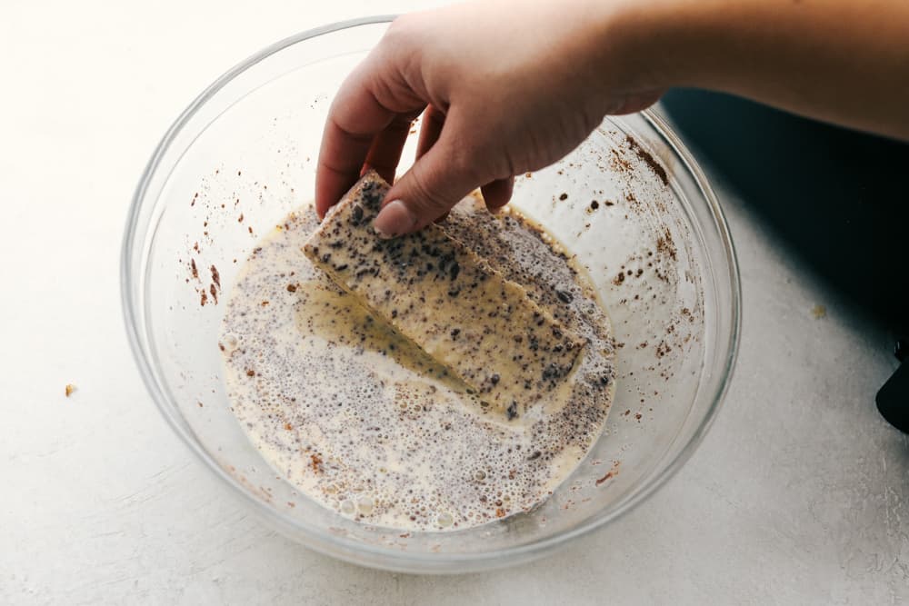 Dipping french toast sticks in egg mixture.