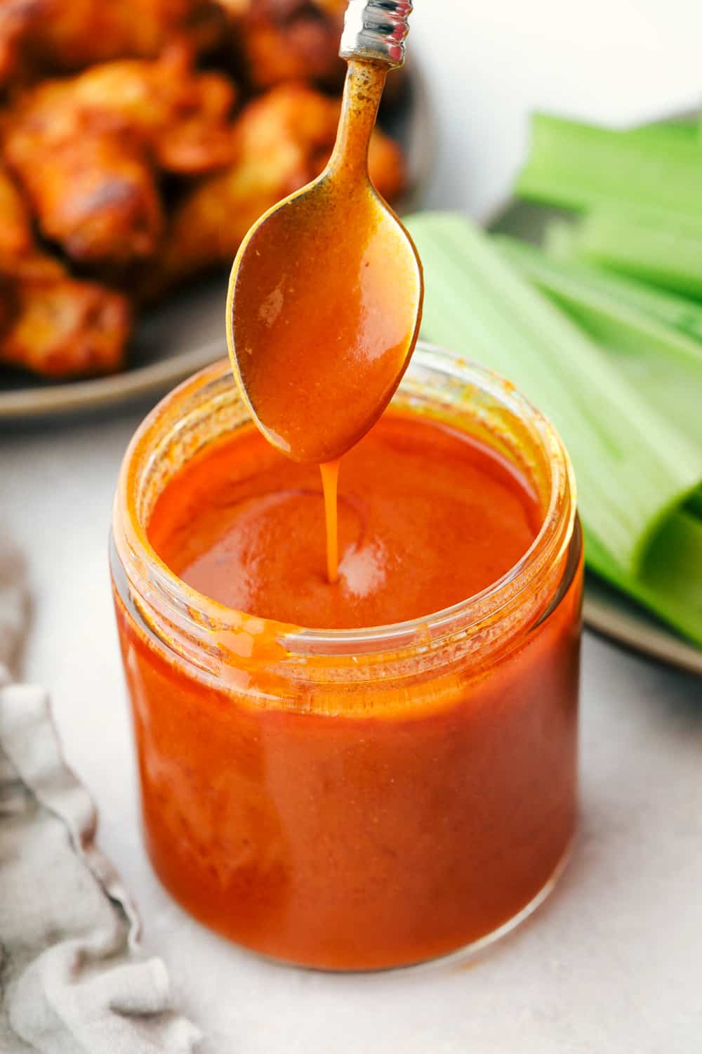 Spooning buffalo sauce into a jar to keep. 