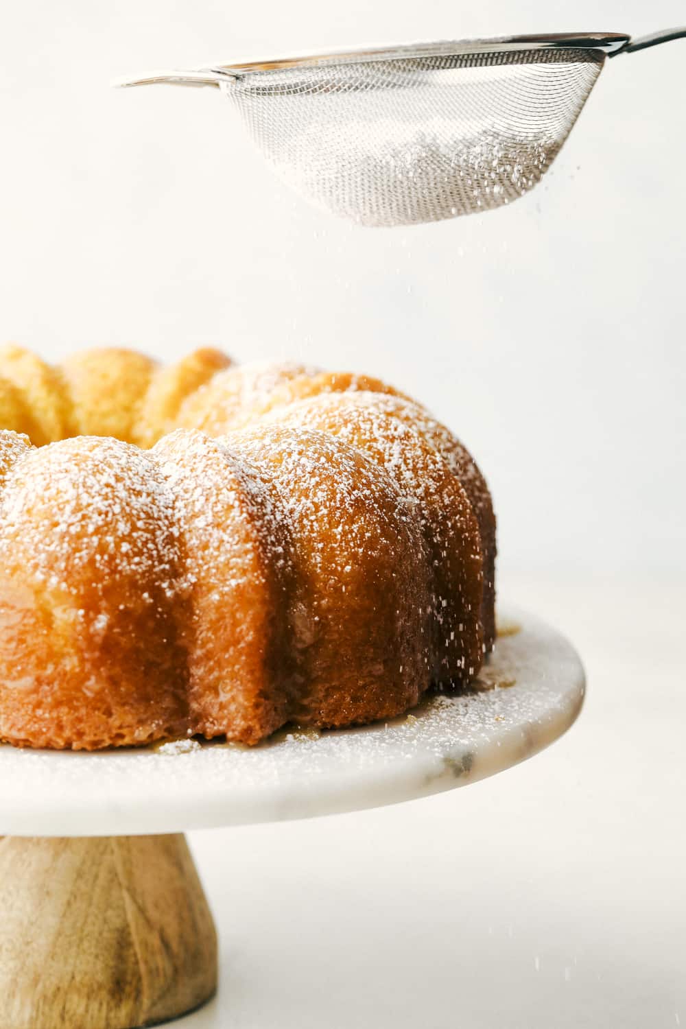 Sprinkling the cake with powder sugar. 