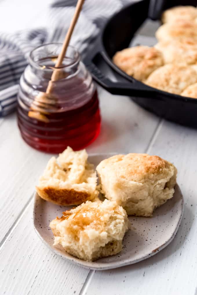 a biscuit on a plate with honey on it