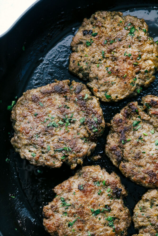 Homemade sausage sizzling in a pan. 