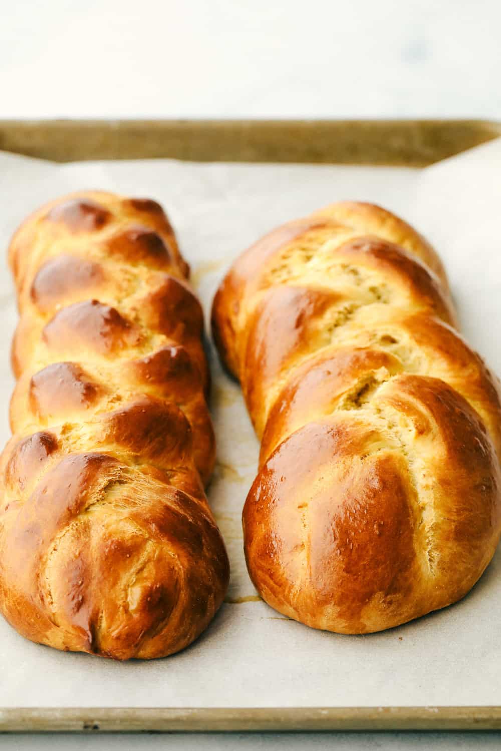 Two baked loaves of Challah golden brown. 