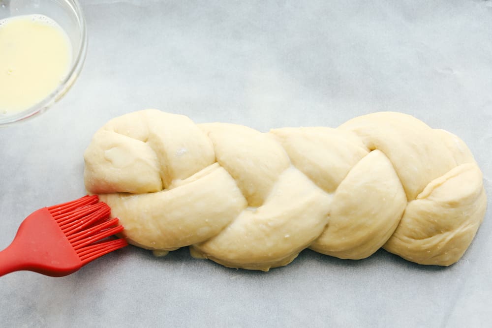 Putting an egg wash on raised dough. 