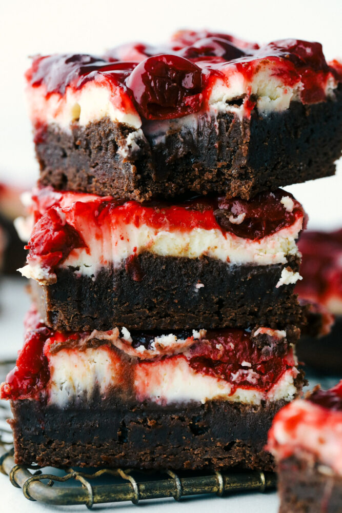 Brownies stacked on top of each other and one with a bite out of it. 