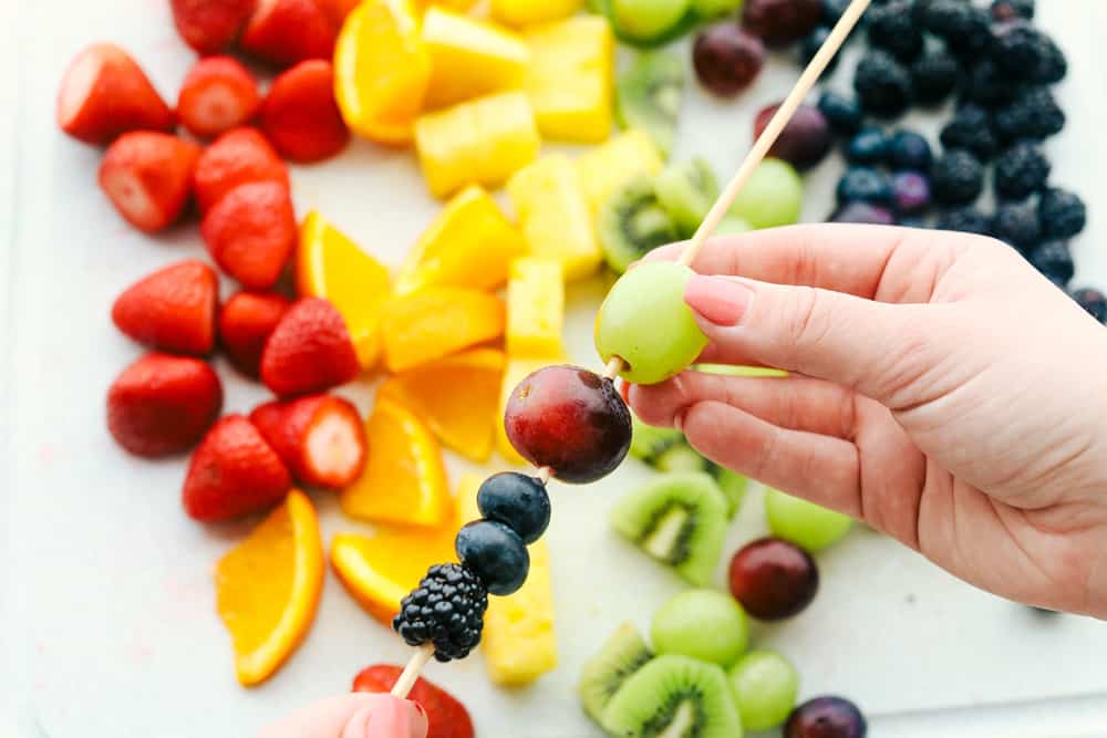 Assembling the fruit on wooden skewers. 