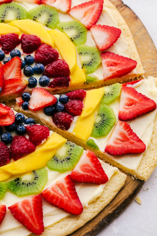 Taking a slice of fruit pizza. 