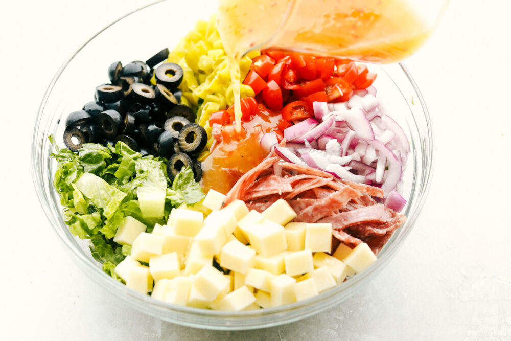 Pouring the dressing over the salad ingredients. 