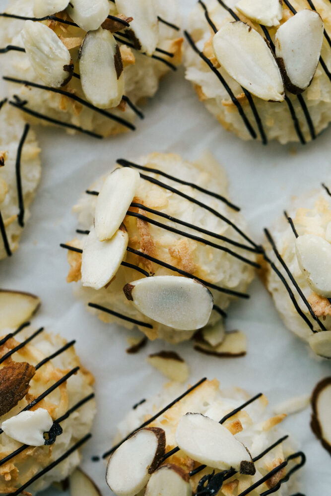 Up close shot of Almond joy macaroons with chocolate drizzle and sliced almonds. 