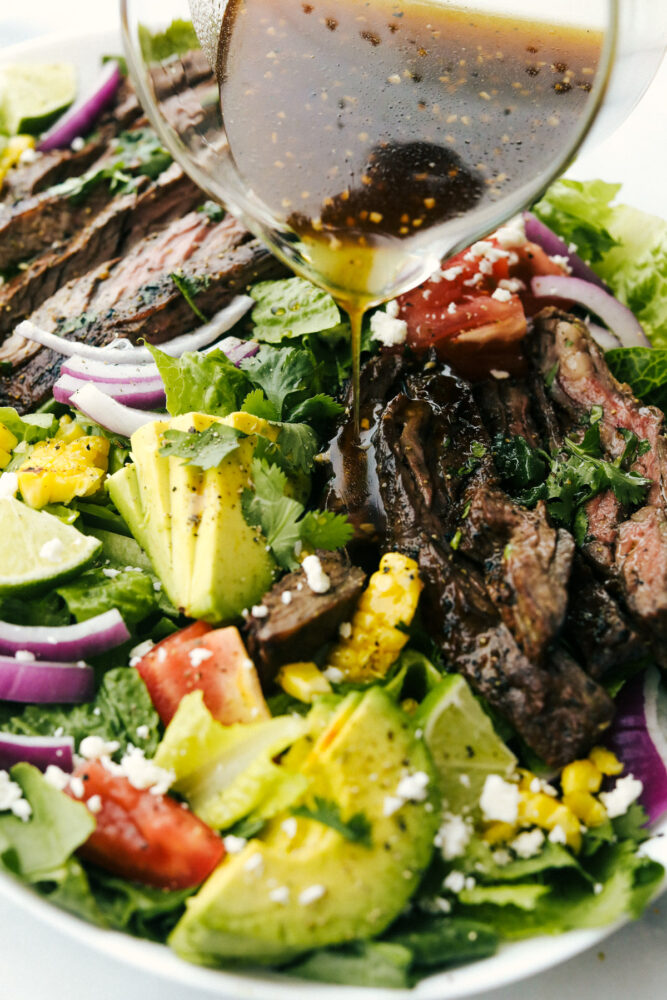 Pouring honey balsamic glaze over salad.