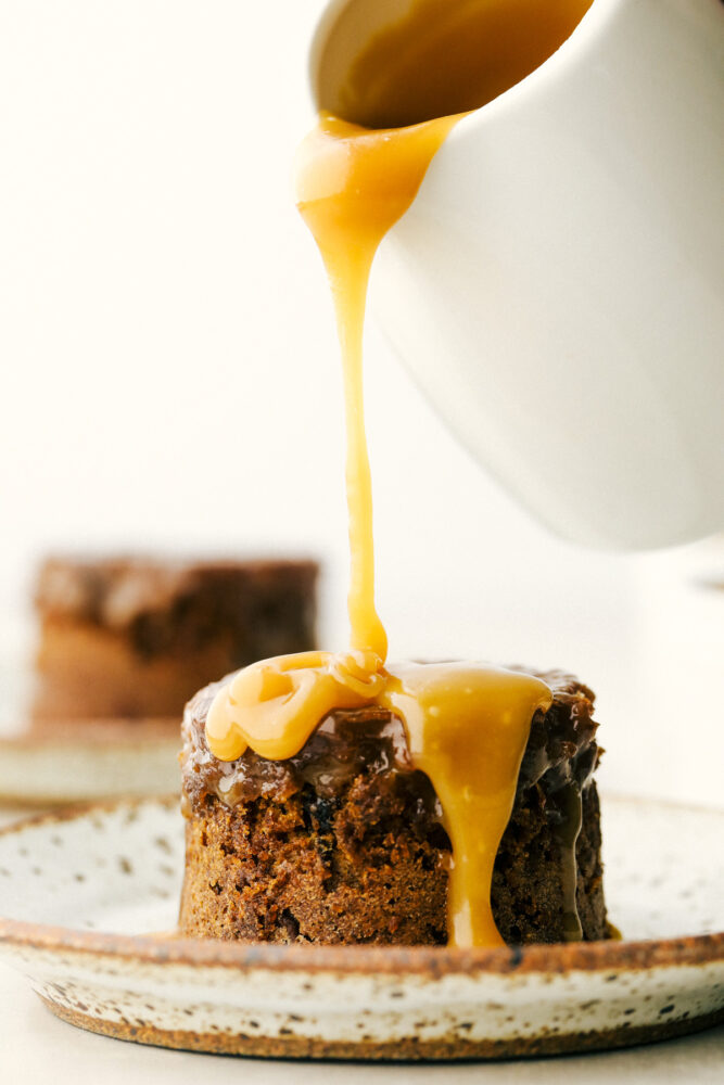 Pouring toffee sauce over the sticky pudding. 