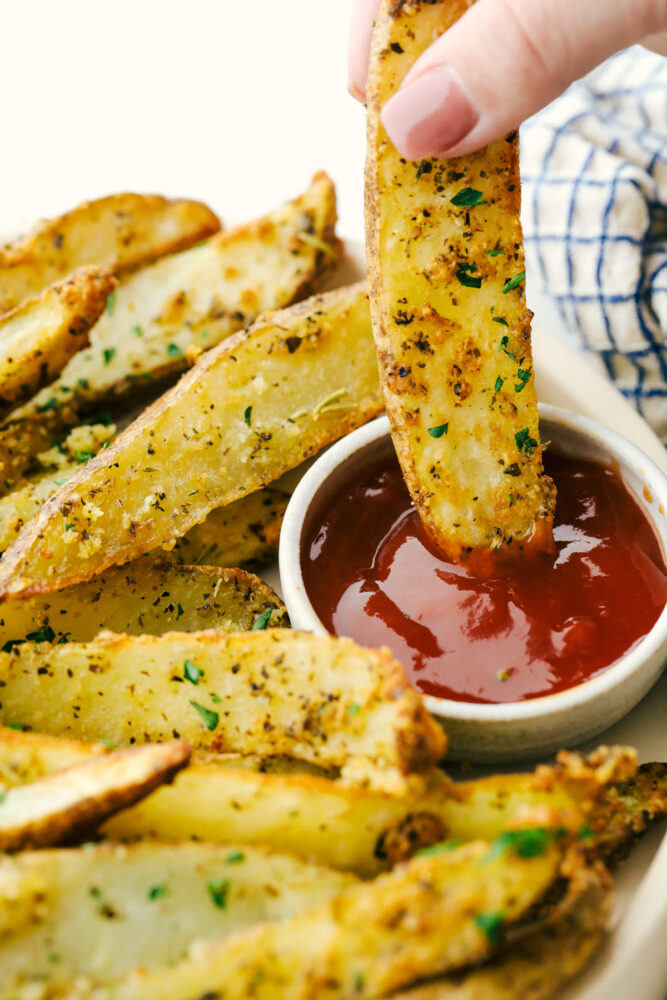 Dipping a potato wedge in some ketchup. 