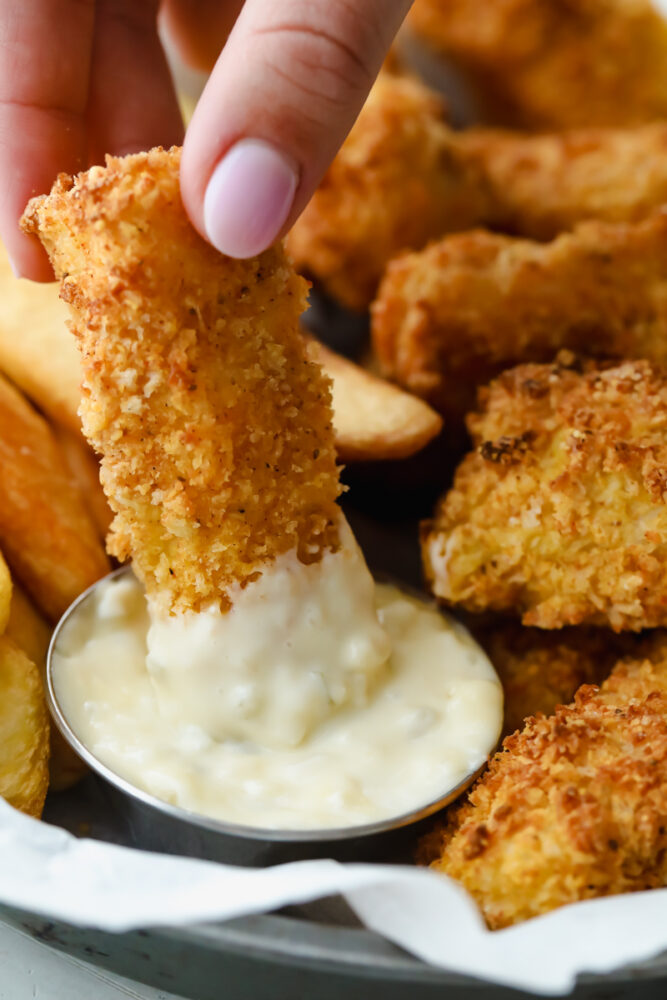 Dipping a homemade fish stick in tartar sauce. 