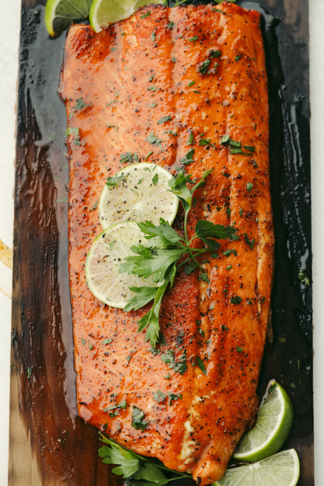 Grilled salmon on cedar plank with garnish.