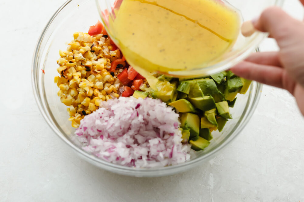 Pouring the dressing over the salad. 