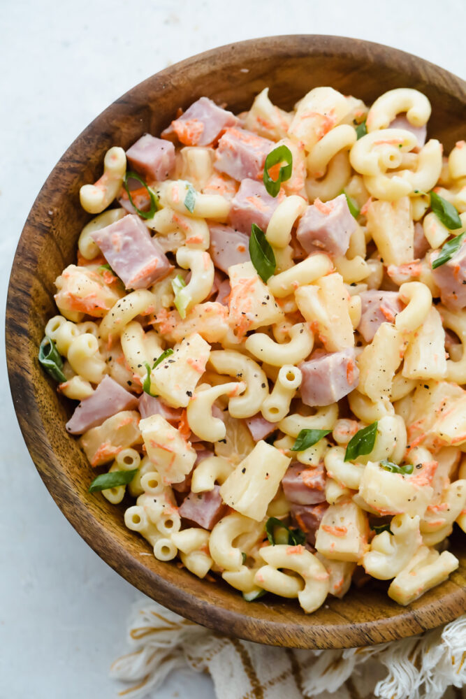 A wooden bowl with hawaiian macaroni salad in it. 