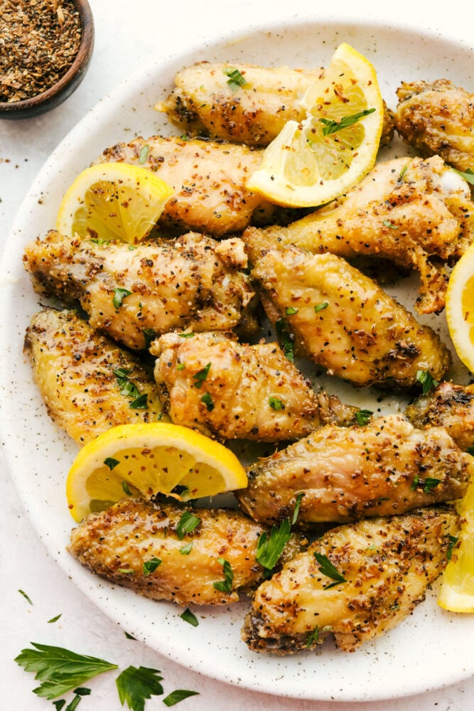 Lemon Pepper Wings with lemon garnish on plate.