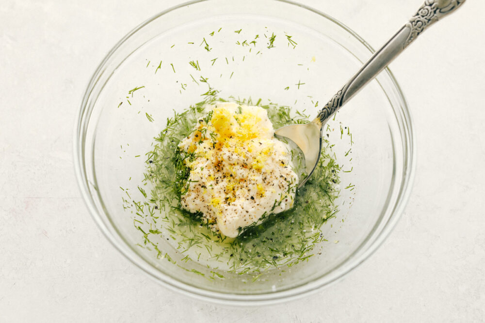 Shrimp pasta salad ingredients being mixed in a small bowl