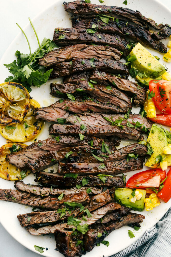 Skirt steak grilled and sliced on a white plate. 