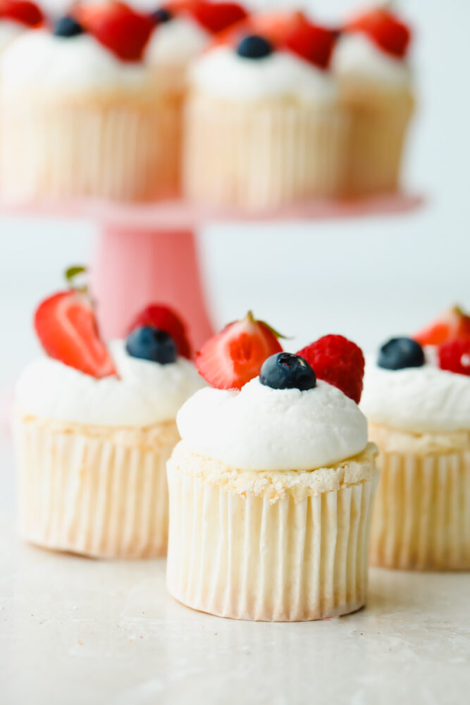 Angel Food Cupcakes topped with blueberries and strawberries.